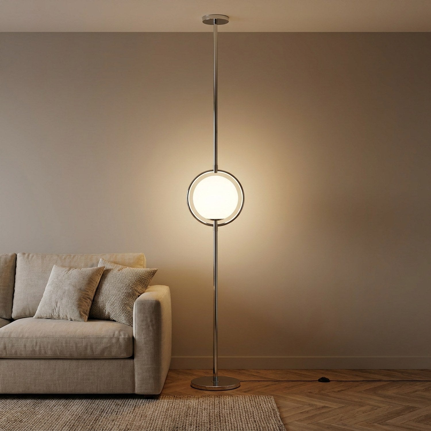 Lampadaire colonne chrome avec boule lumineuse en verre dépoli allumée dans un salon contemporain
