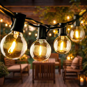 Guirlande lumineuse solaire aux ampoules guinguette allumées drapées au-dessus d'une terrasse en bois au crépuscule