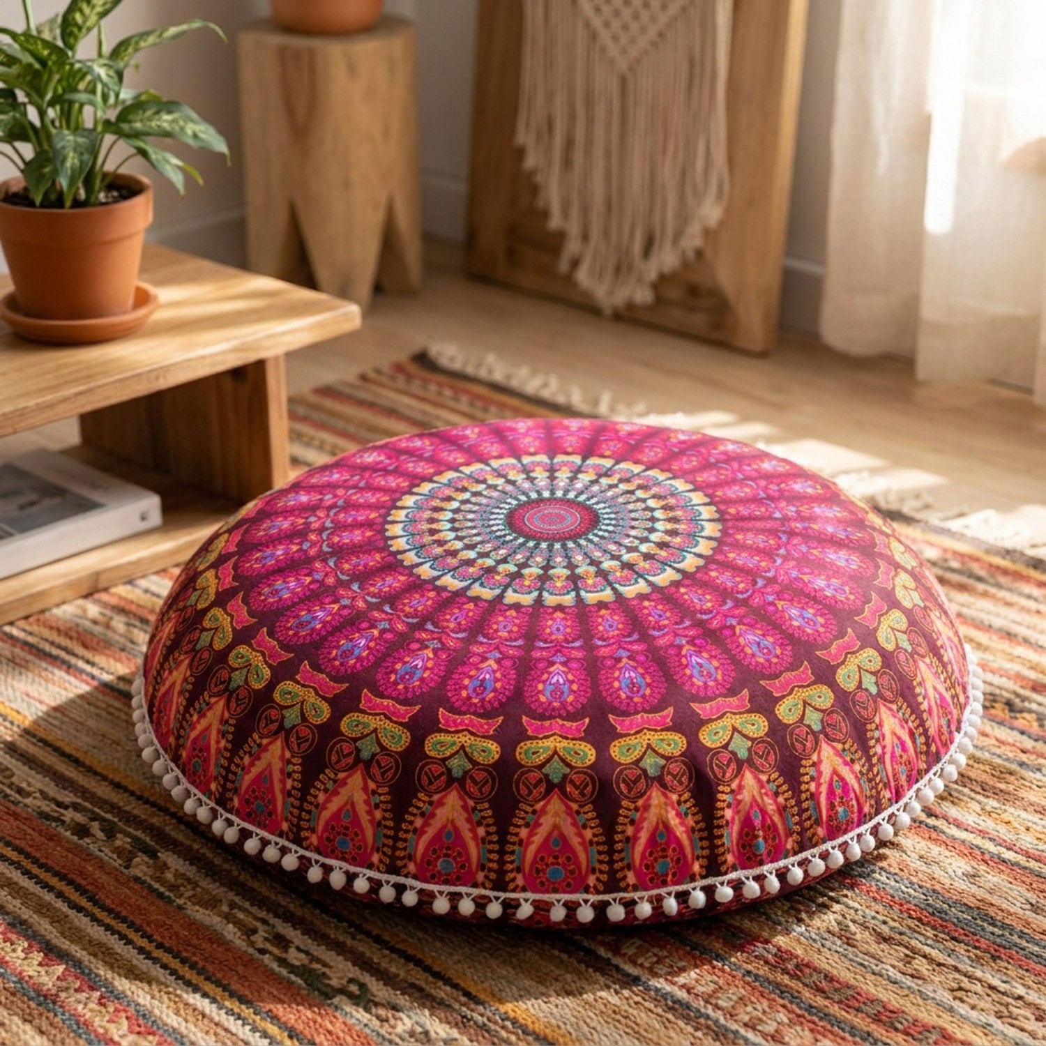Housse de coussin de sol ronde bordeaux à motif mandala posée sur un tapis bohème