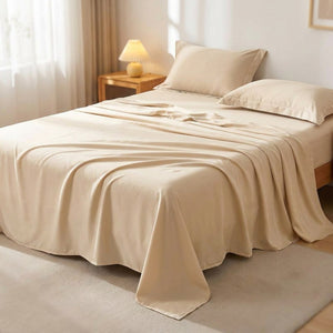 Drap plat en coton égyptien beige posé sur un lit fait dans une chambre lumineuse et chaleureuse
