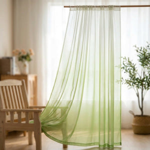 Voilage tulle dégradé vert suspendu à une tringle devant une fenêtre lumineuse