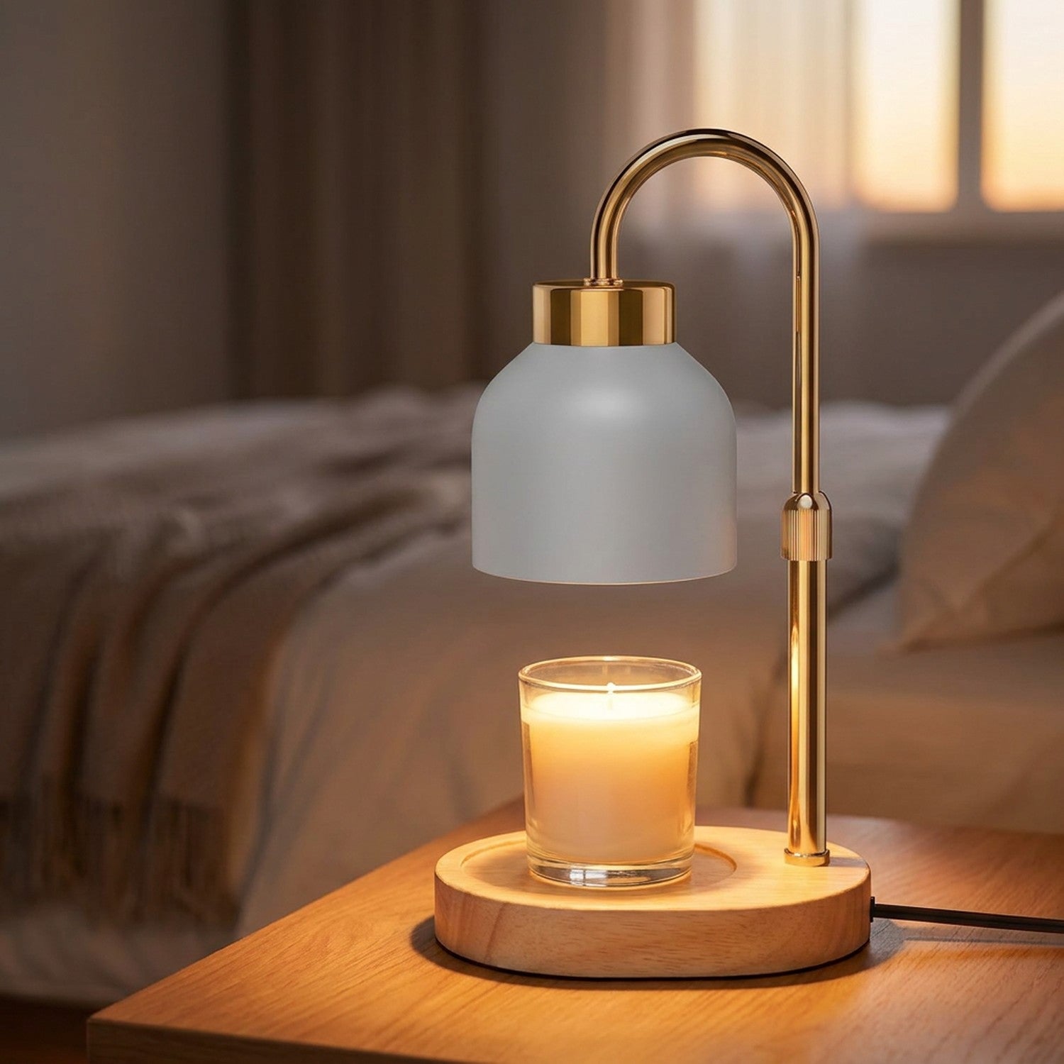 Lampe chauffe-bougie blanche au bras doré diffusant une lumière chaude au-dessus d'une bougie allumée