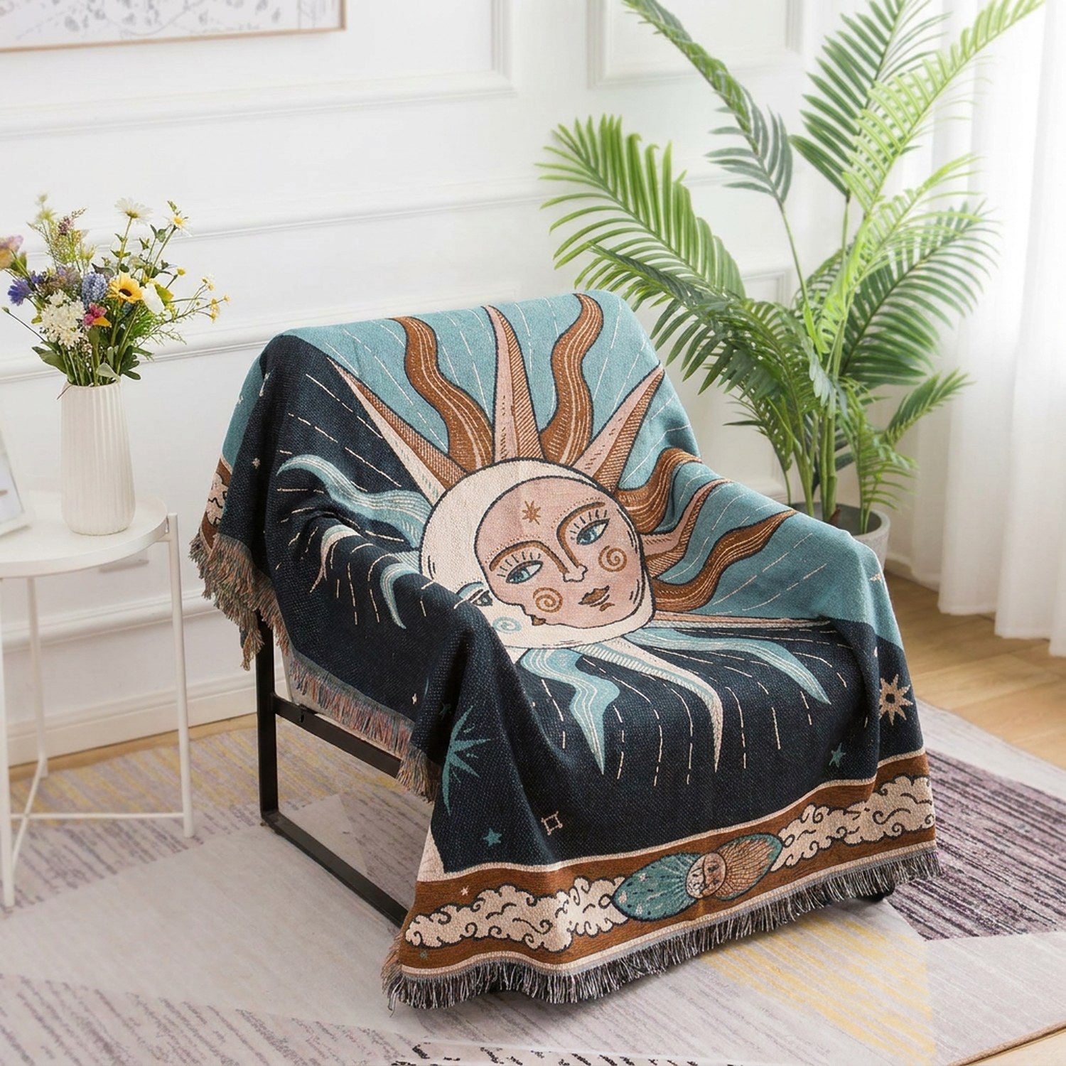 Tapisserie plaid représentant un soleil et une lune céleste en bleu et brun drapée sur un fauteuil