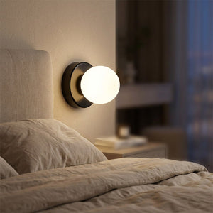 Applique murale LED en verre dépoli de forme boule au design nordique épuré dans une chambre