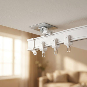 Rail de rideau flexible blanc fixé au plafond avec crochets près d'une fenêtre lumineuse
