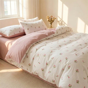 Parure de lit blanche à motif tulipe rose posée sur un lit dans une chambre lumineuse
