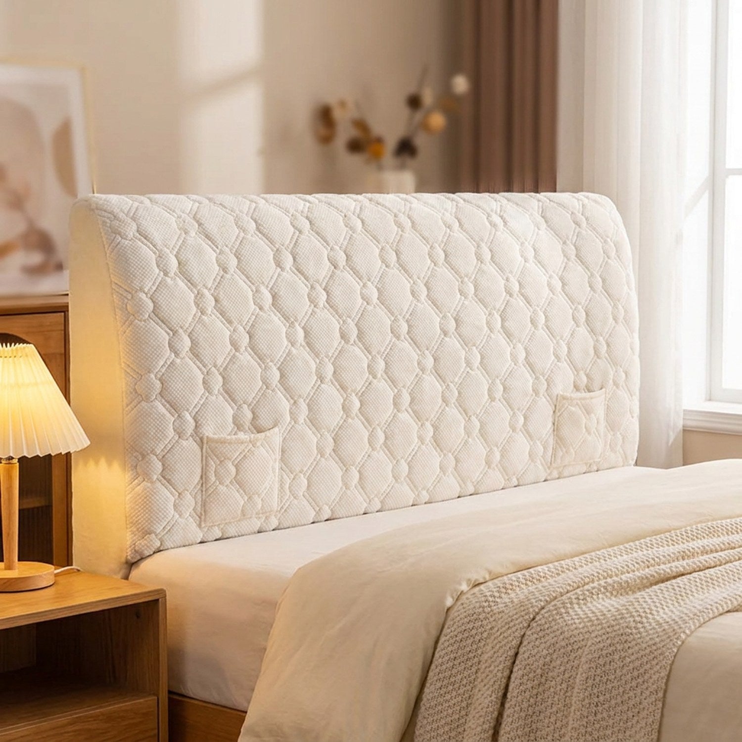 Housse de tête de lit matelassée beige installée sur un lit dans une chambre chaleureuse
