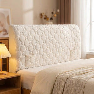 Housse de tête de lit matelassée beige installée sur un lit dans une chambre chaleureuse