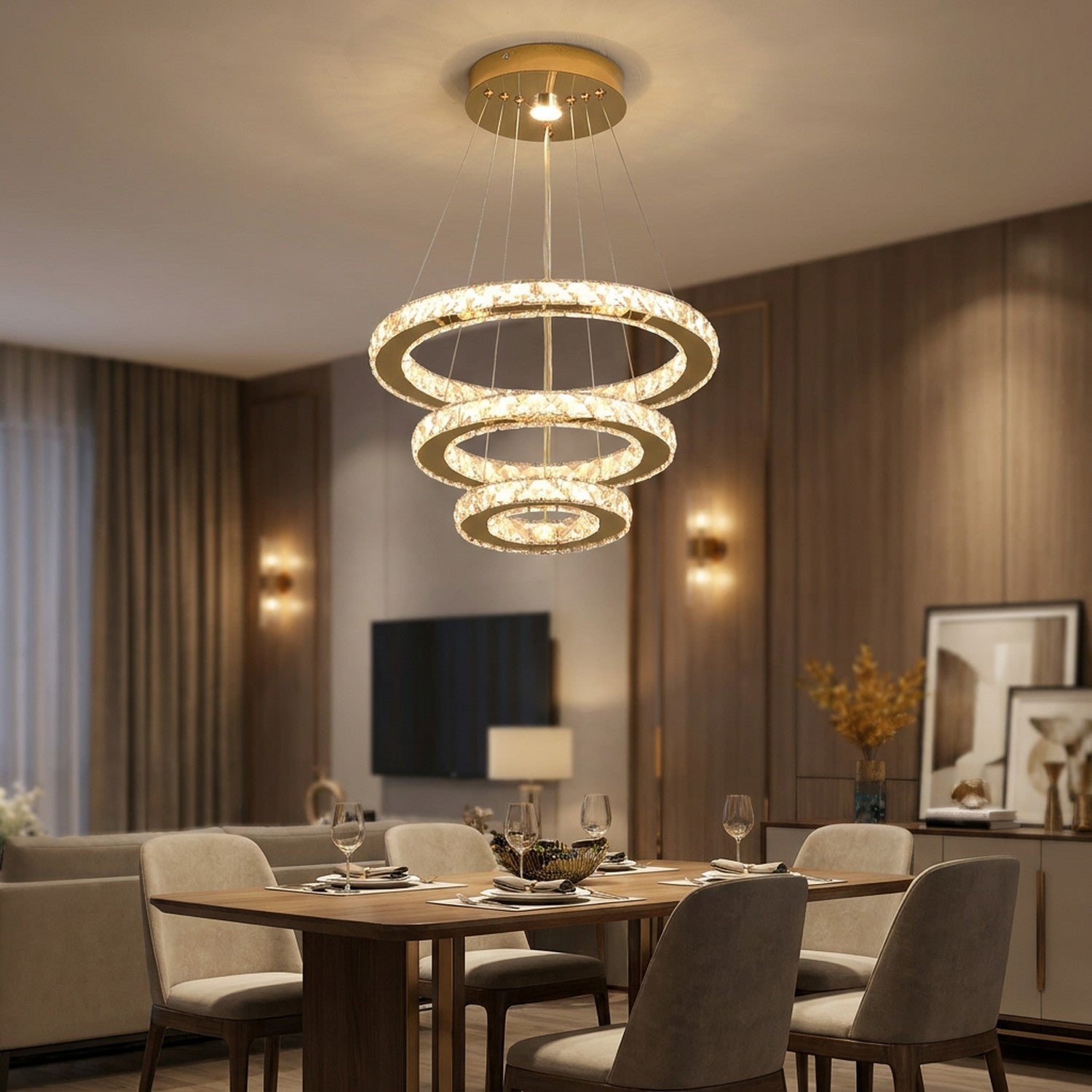 Lustre en cristal doré à trois anneaux suspendu au-dessus d'une table de salle à manger élégante