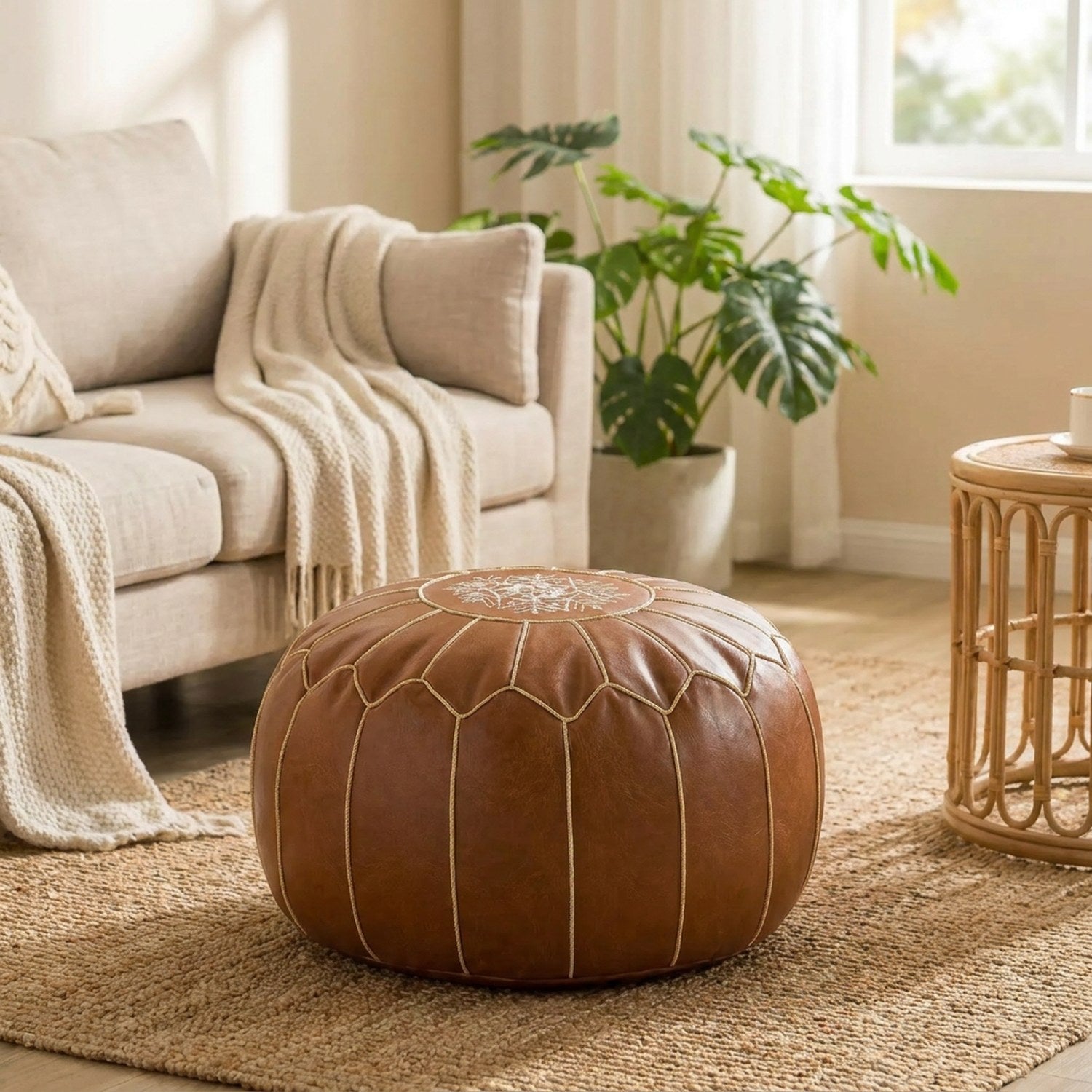 Pouf marocain rond en cuir PU marron à garnir posé sur un tapis dans un salon bohème