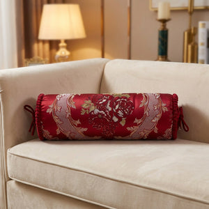Housse de traversin cylindrique en jacquard rouge brodé de fleurs posée sur un canapé