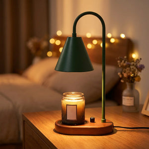 Lampe chauffe-bougie verte avec socle en bois allumée sur une table de chevet