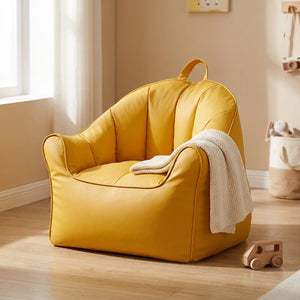 Pouf fauteuil enfant jaune moutarde en similicuir dans une chambre chaleureuse