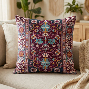 Housse de coussin carrée à motif tapis berbère bordeaux posée sur un canapé en lin beige