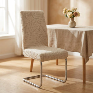 Housse de chaise beige à motif jacquard feuillage installée sur une chaise de salle à manger