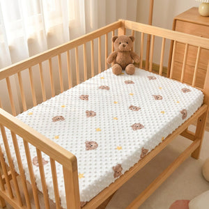 Drap-housse bébé à pois blanc orné de petits oursons et d'étoiles sur un berceau en bois