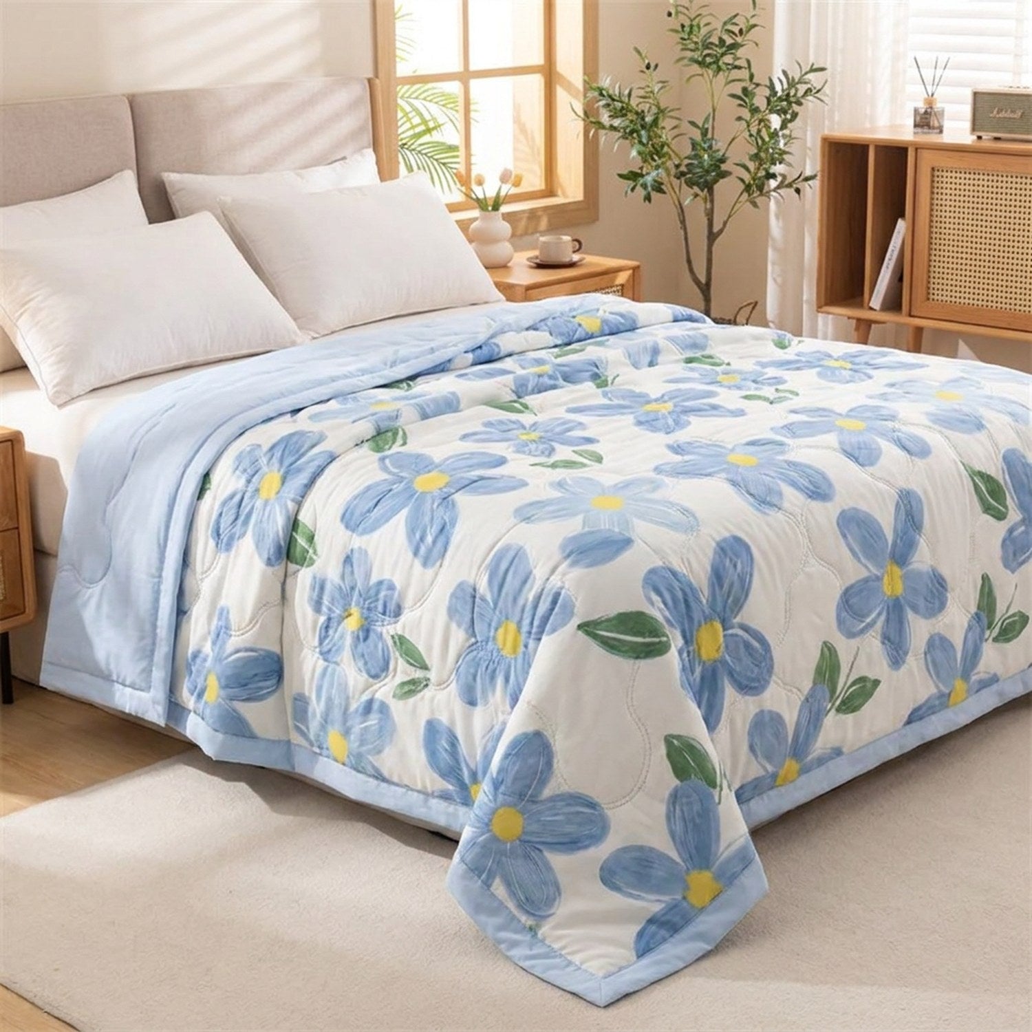 Couette d'été à motif marguerites bleues posée sur un lit dans une chambre cosy