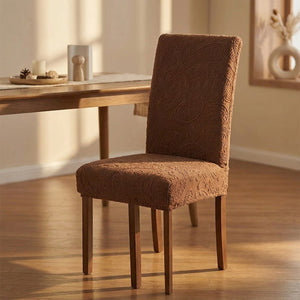 Housse de chaise extensible en jacquard relief marron sur une chaise de salle à manger