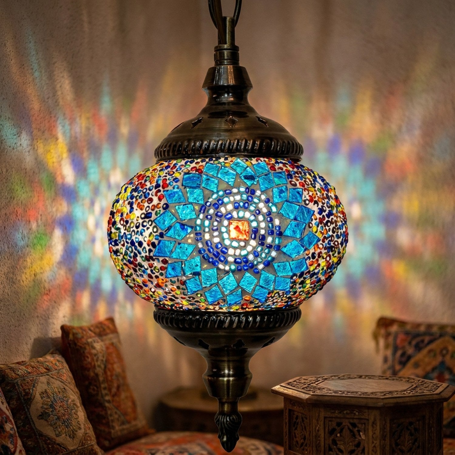 Suspension mosaïque turque en verre bleu allumée projetant une lumière colorée dans un intérieur oriental