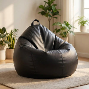 Pouf poire en simili cuir noir posé au sol dans un intérieur cosy