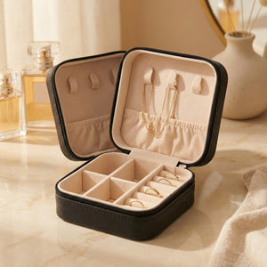 Boîte à bijoux de voyage en cuir noir ouverte avec compartiments et rouleaux à bagues