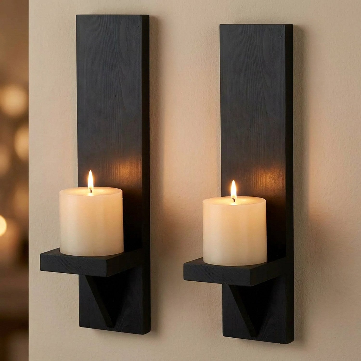 Lot de 2 bougeoirs muraux en bois noir avec une bougie pilier allumée sur chaque tablette