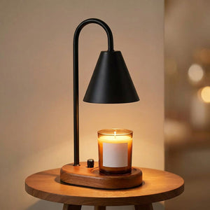 Lampe chauffe-bougie noire avec socle en bois allumée sur une petite table
