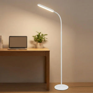 Lampadaire LED à côté d'un bureau en bois éclairant un espace de travail moderne