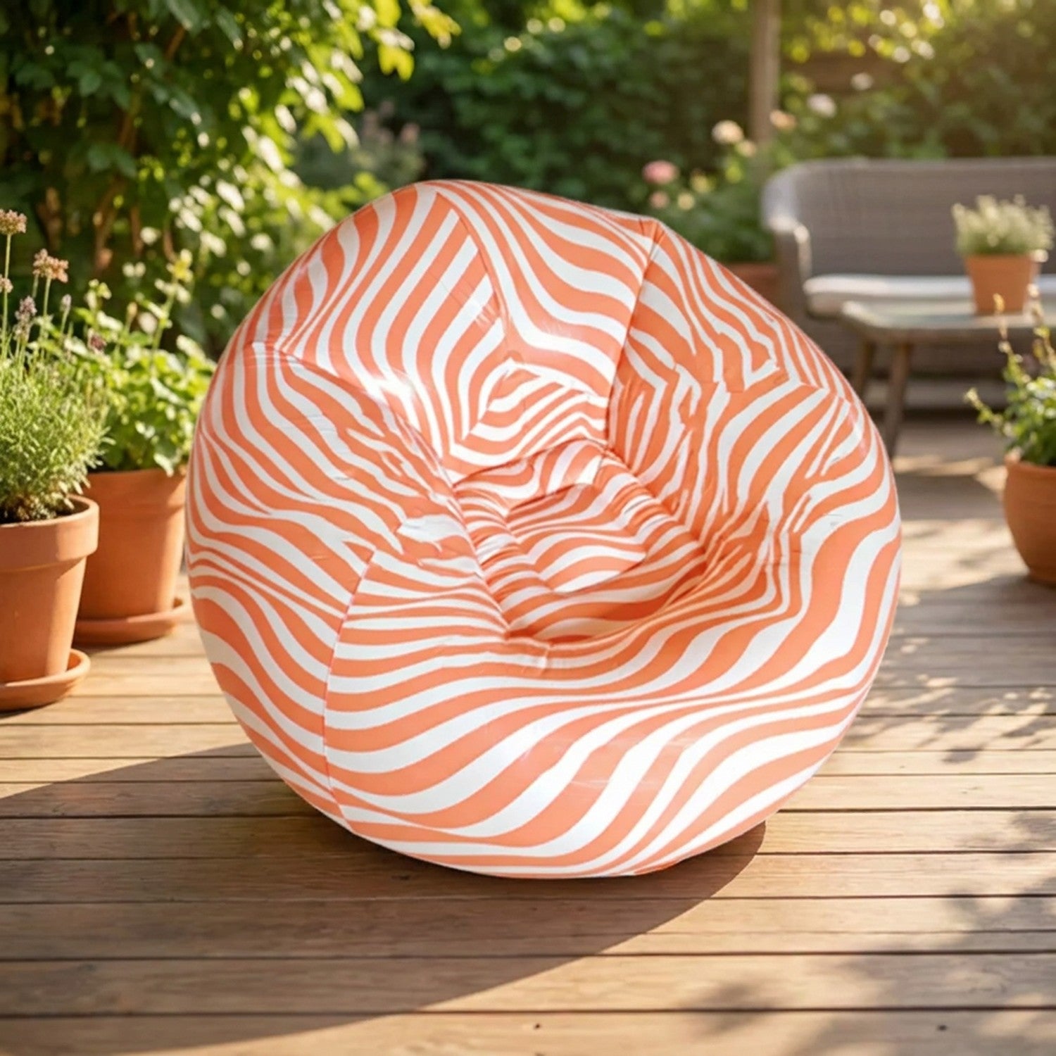 Fauteuil gonflable pouf géant rayé orange sur une terrasse en bois