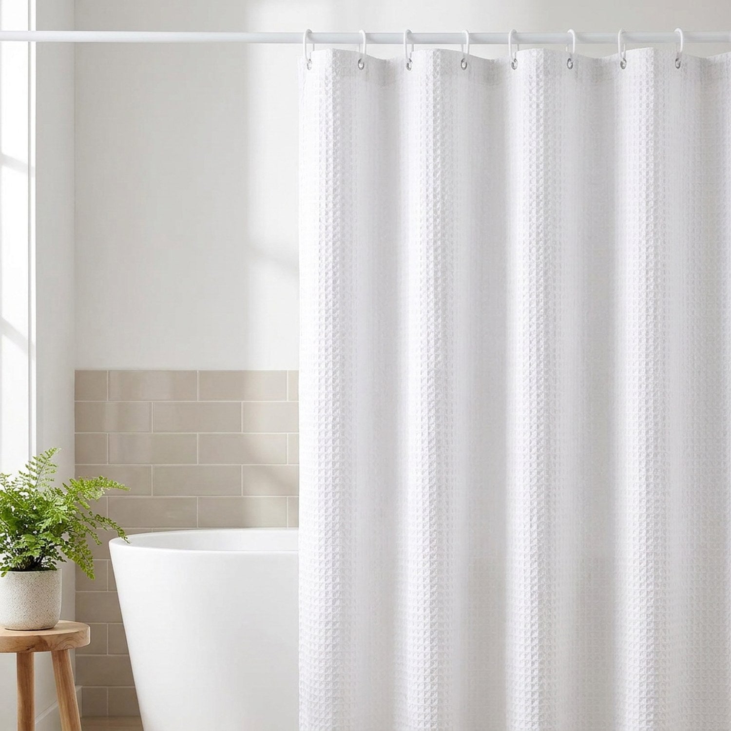 Rideau de douche jacquard blanc gaufré suspendu devant une baignoire