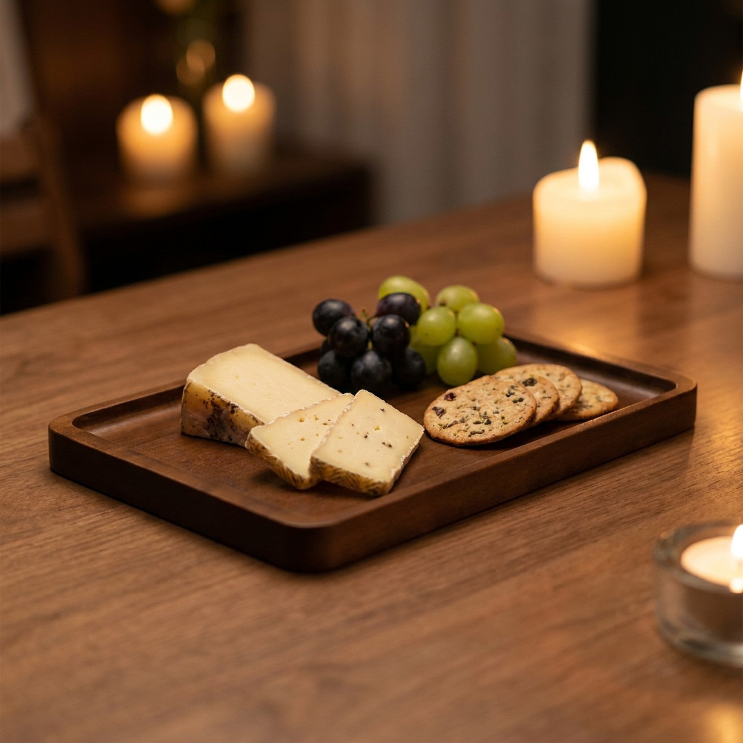 Plateau en bois foncé garni de fromage de raisin et de crackers pour un apéritif à la bougie