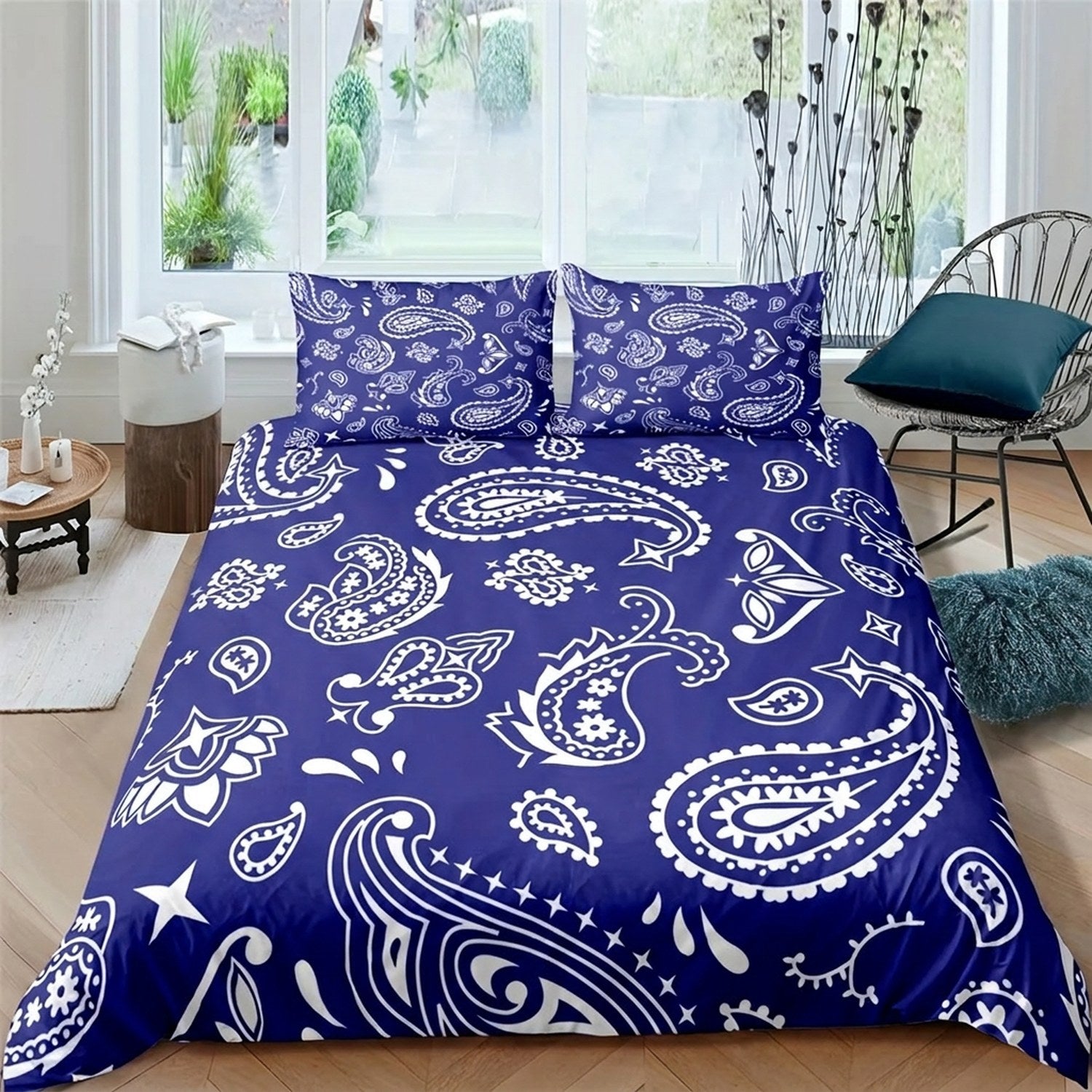 Parure de lit paisley bleu roi à grand motif sur un lit dans une chambre lumineuse