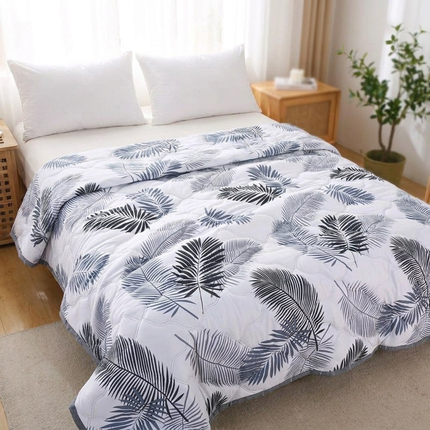 Couvre-lit d'été blanc à motif feuillage bleu sur un lit clair