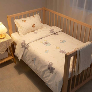 Parure de lit bébé sur un berceau avec table de chevet et lampe chaleureuse