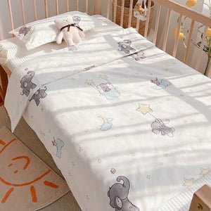 Parure de lit bébé 3 pièces en coton à motif éléphants installée sur un berceau dans une chambre enfant lumineuse