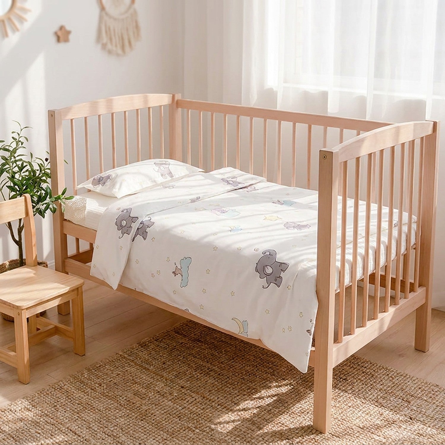 Parure de lit bébé motif éléphants dans une chambre enfant avec chaise en bois