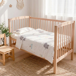 Parure de lit bébé motif éléphants dans une chambre enfant avec chaise en bois