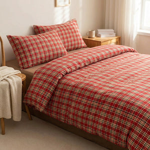 Parure de lit à carreaux rouges dans une chambre lumineuse avec chaise en bois