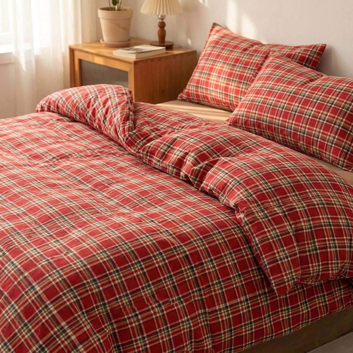 Parure de lit à carreaux rouges installée sur un lit fait dans une chambre chaleureuse