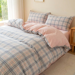 Parure de lit 3 pièces à carreaux roses sur un lit fait