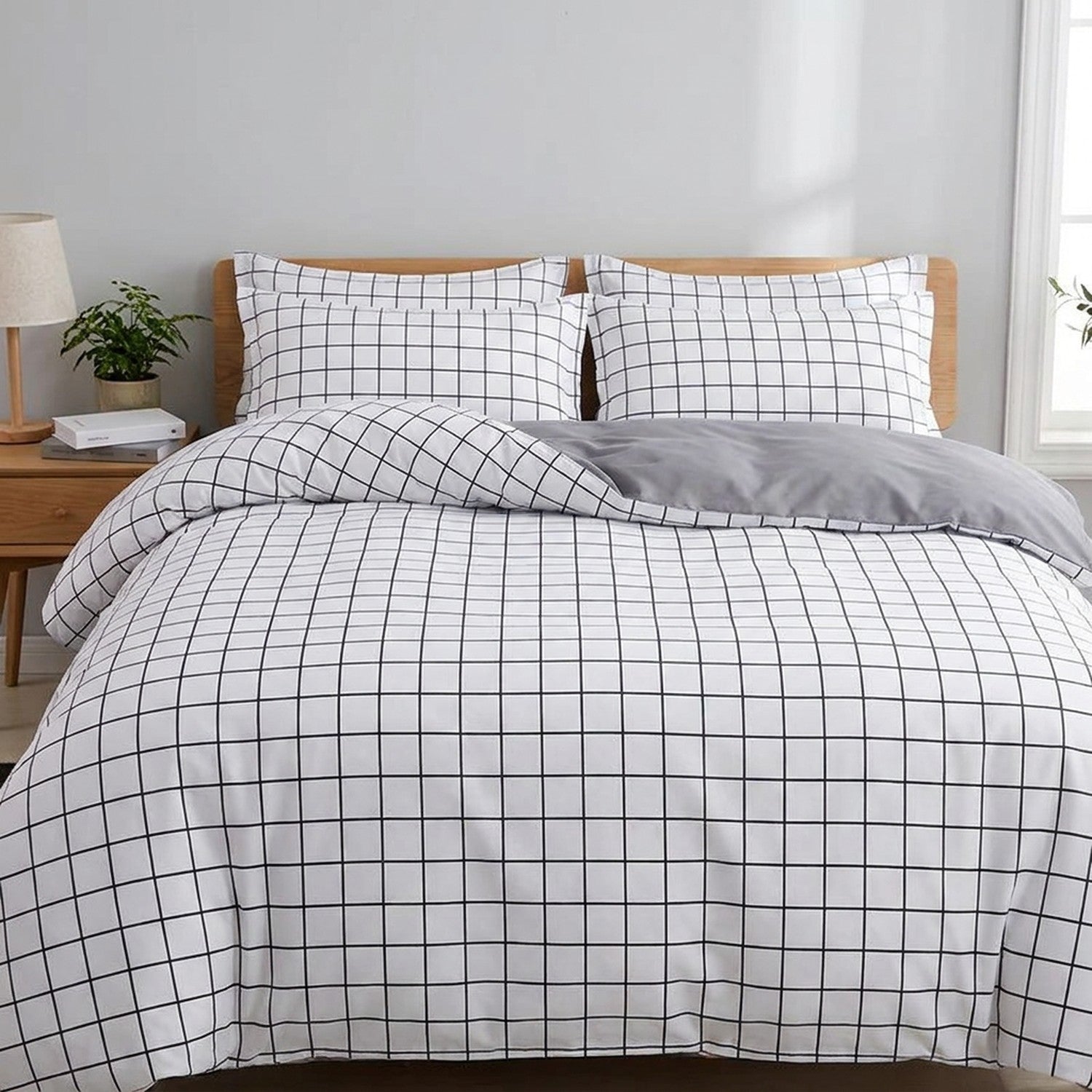 Parure de lit à motifs carreaux installée sur un lit dans une chambre lumineuse
