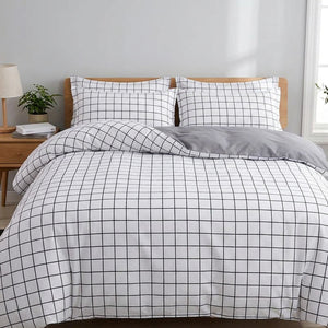 Parure de lit à motifs carreaux installée sur un lit dans une chambre lumineuse