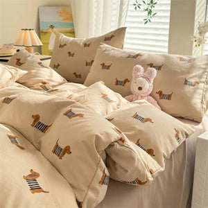 Housse de couette motif chien beige posée sur un lit avec taies assorties