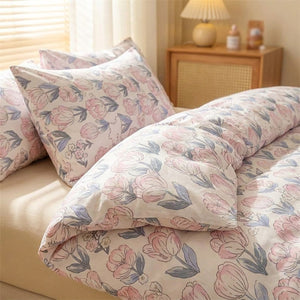 Housse de couette et taie motif fleurs roses en gros plan sur un lit dans une chambre chaleureuse