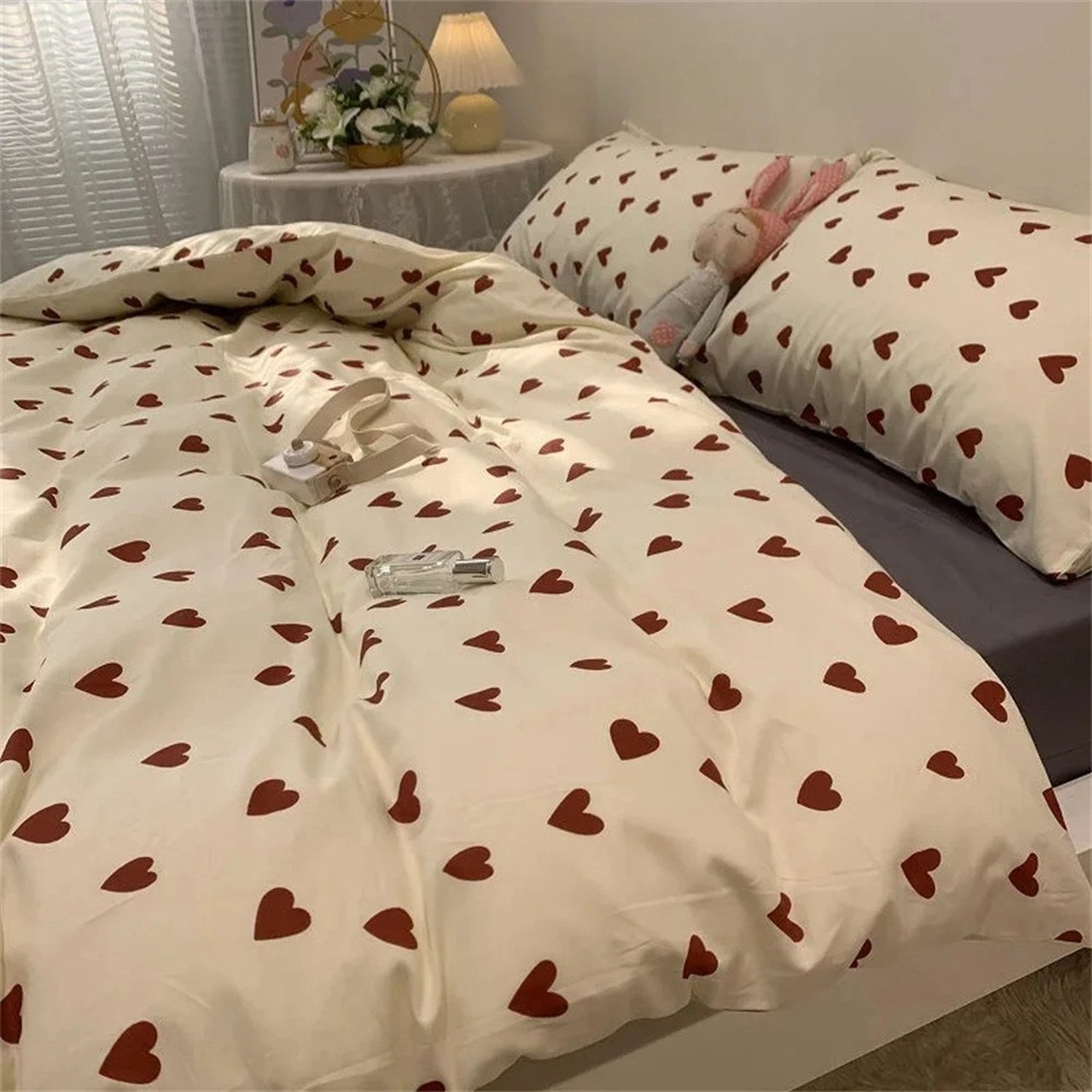 Parure de lit cœur rouge avec taies assorties et peluche lapin sur un lit