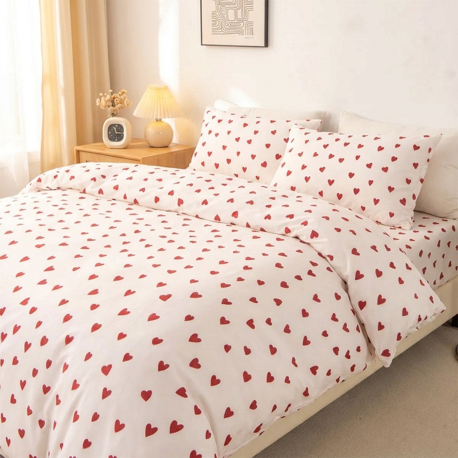 Parure de lit 3 pièces à motif petit cœur rouge sur fond crème installée sur un lit dans une chambre lumineuse