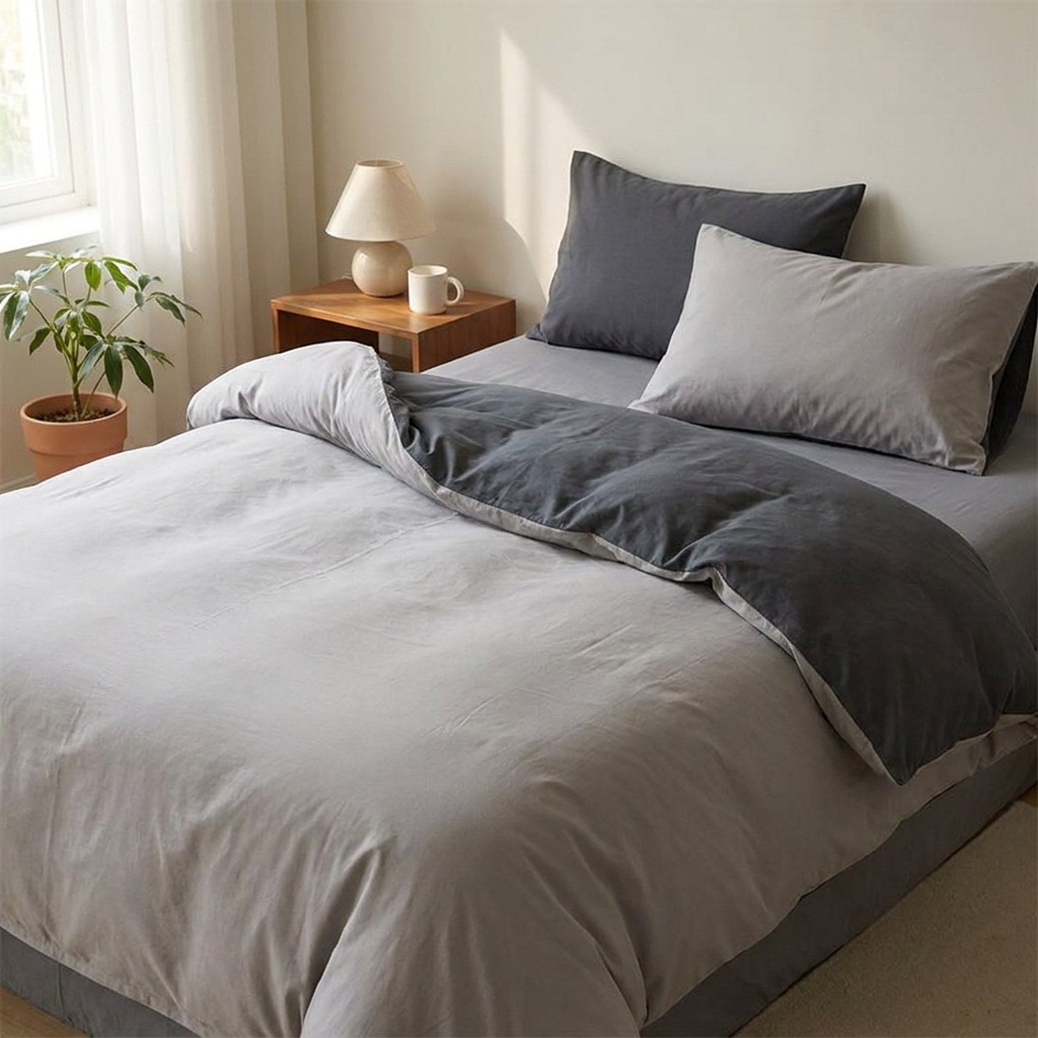 Parure de lit en coton lavé gris clair et anthracite sur un lit dans une chambre moderne