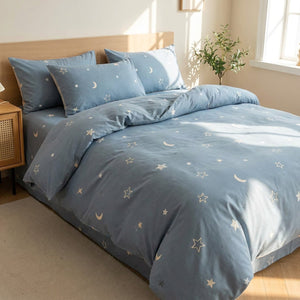 Parure de lit enfant motif étoiles et lune sur un lit vue de côté dans une chambre douce