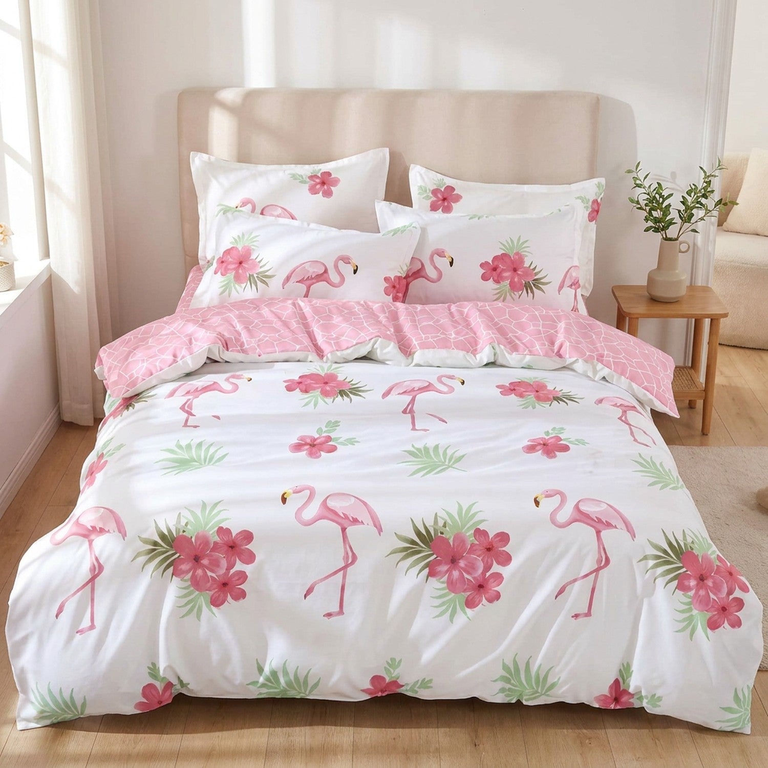 Parure de lit flamant rose motif tropical blanc installée sur un lit fait dans une chambre lumineuse