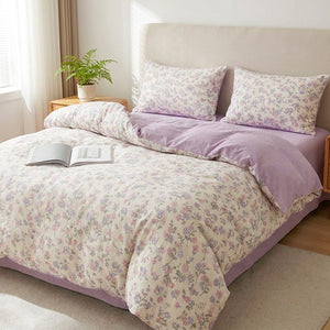 Parure de lit fleurie aux motifs de fleurs violettes sur un lit dans une chambre douce et lumineuse